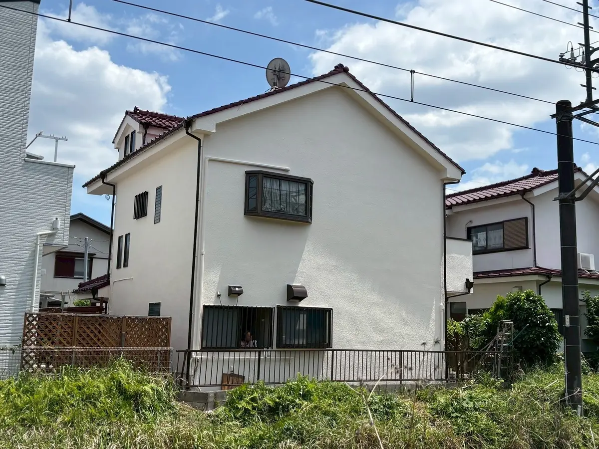 塗り替えを終えた白い戸建て住宅の外観