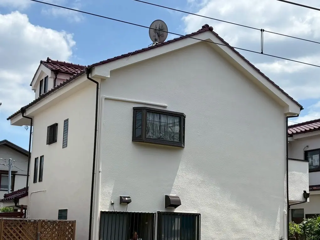 塗り替えを終えた白い戸建て住宅の外観