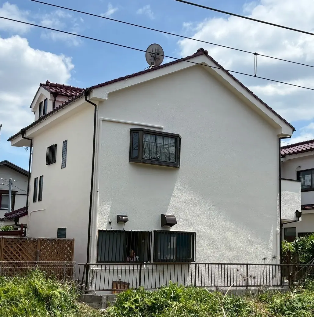 塗り替えを終えた白い戸建て住宅の外観